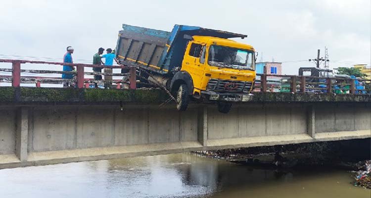 জাউয়া বাজারে সেতুর রেলিং ভেঙে ঝুলে পড়ল ডাম্প ট্রাক